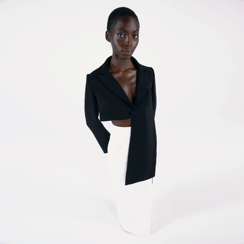 Square shaped asymmetric crop jacket with long panels, with a long slim pencil skirt with thigh high square slit.