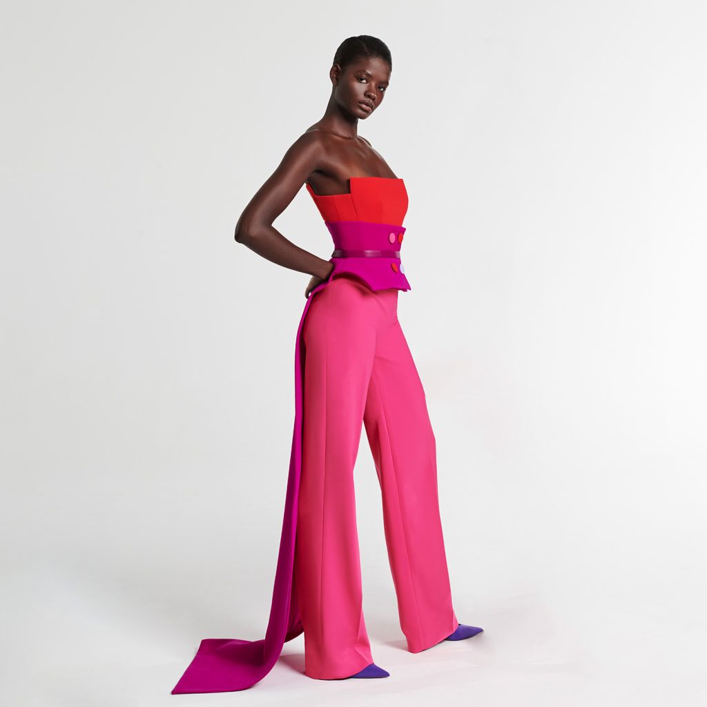 Strapless structured layered jumpsuit, tri-colored waist tail extending to back bow , multicolored tailored buttons and belt.